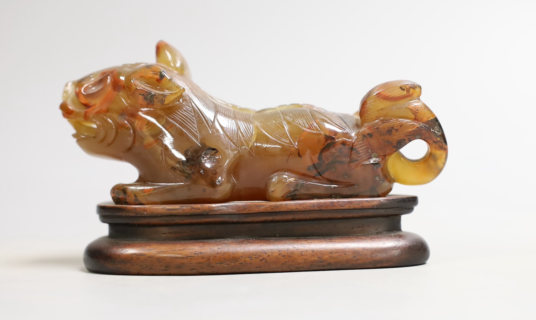 A Chinese agate recumbent lion dog figure, 13cm long